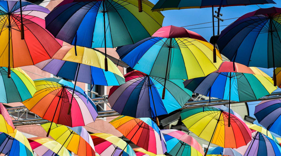 Viele bunte Regenschirme nebeneinander schwebend