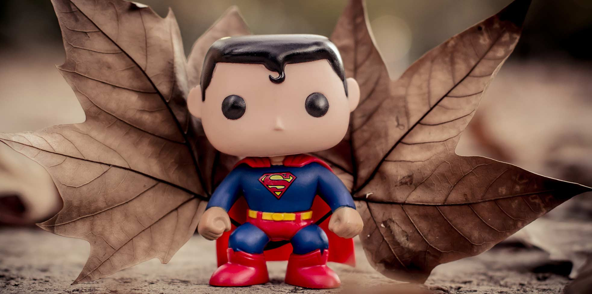 Eine Superman-Spielfigur mit Herbst-Blättern als Flügel